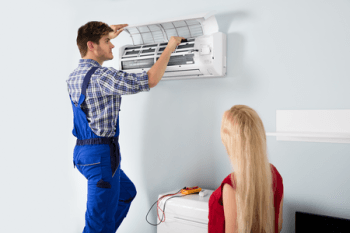 HVAC technician fixing a wall unit HVAC system