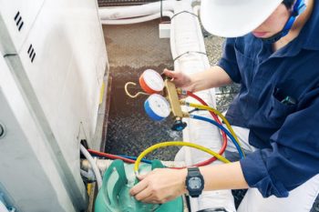 Technician maintaining a HVAC unit