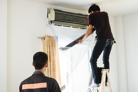 Technicians replacing a ductless mini-split unit